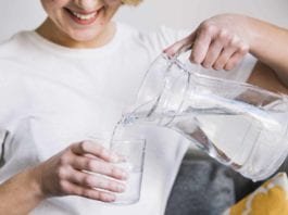 Ilustrasi Wanita sedang menuangkan air ke dalam gelas